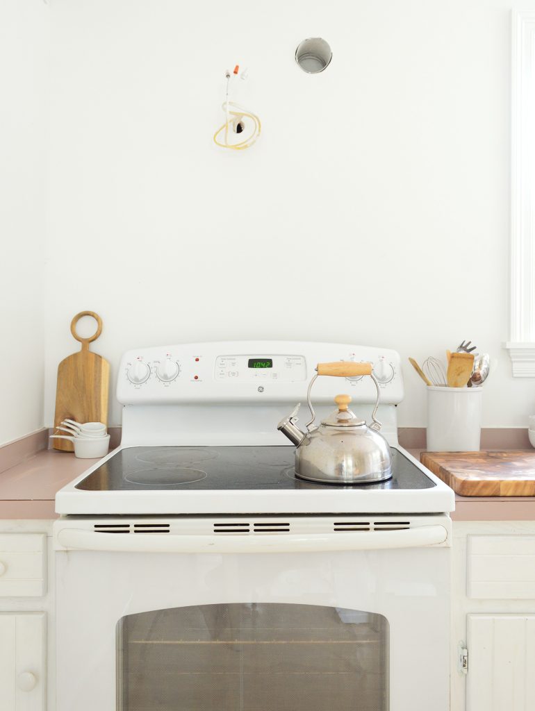 Empty Wall Space Above White Stove In Minimal White Kitchen