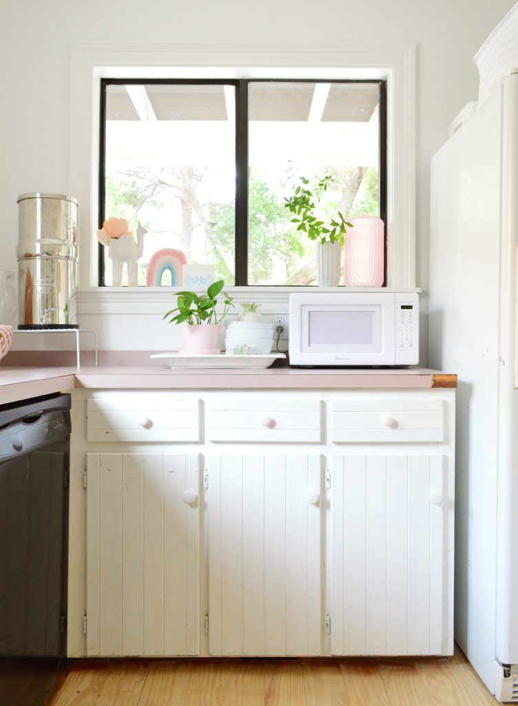 Before photo of kitchen with exposed white hinges on cabinet frames