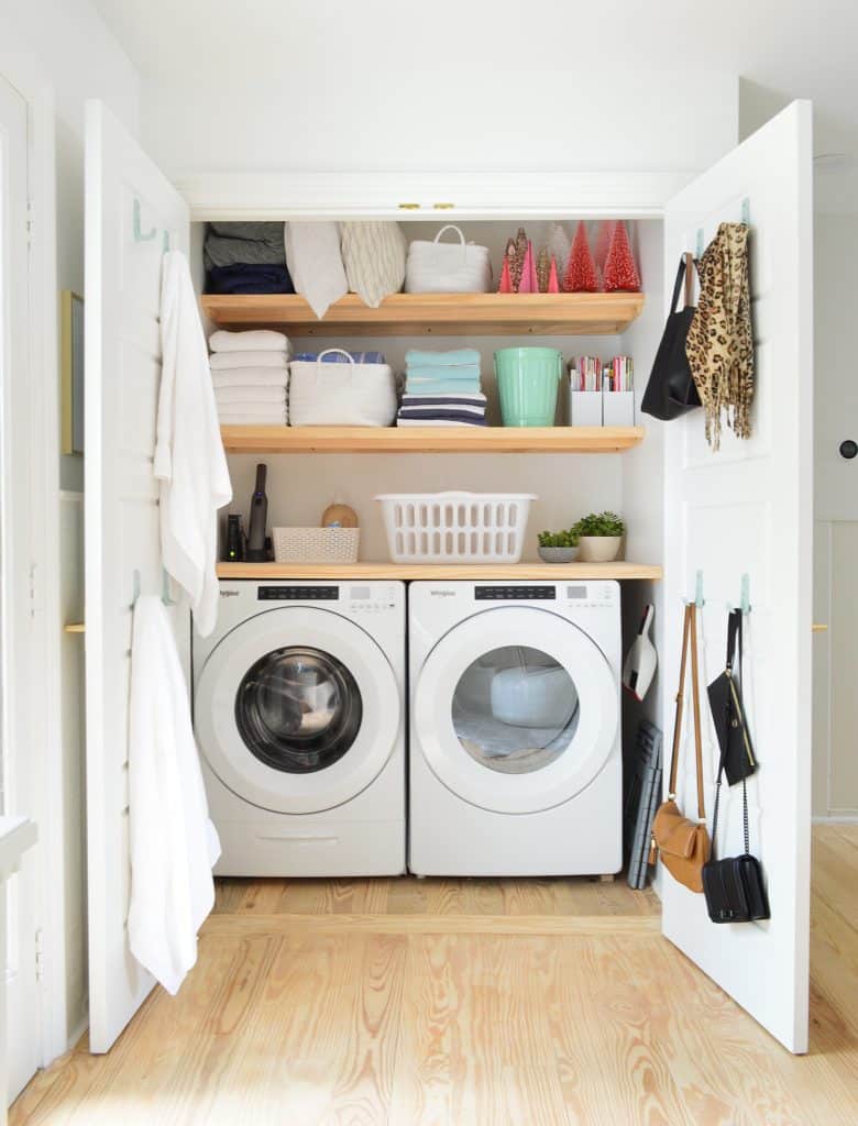 Laundry room closet open showing wood shelving