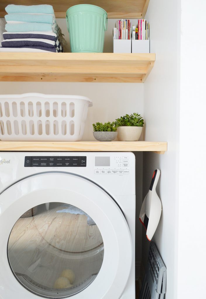 Profile view of laundry closet with DIY wood floating shelves