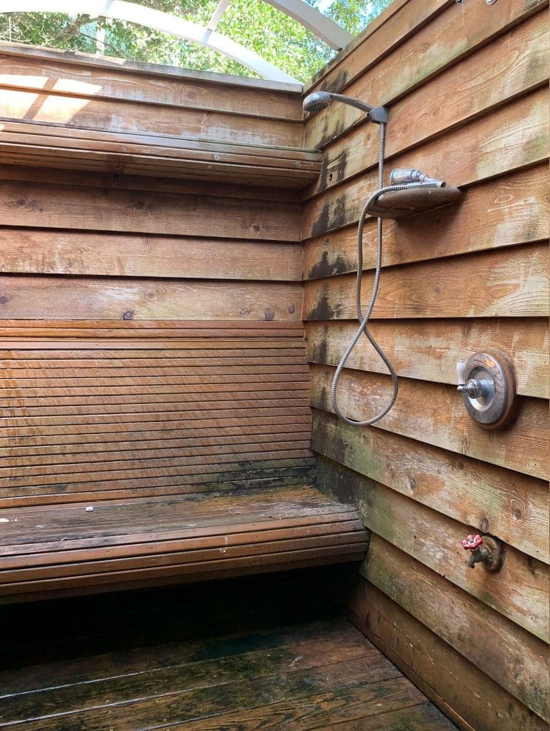 Before photo of wood outdoor shower with grime and mold