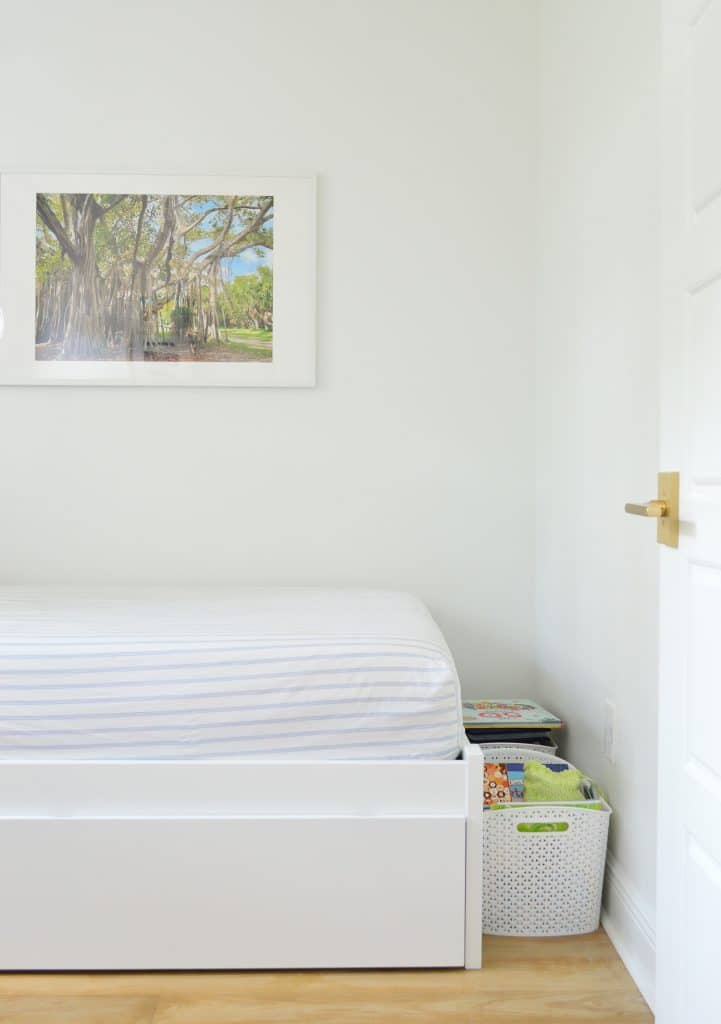 Before photo of boys bedroom with baskets on the floor near foot of bed