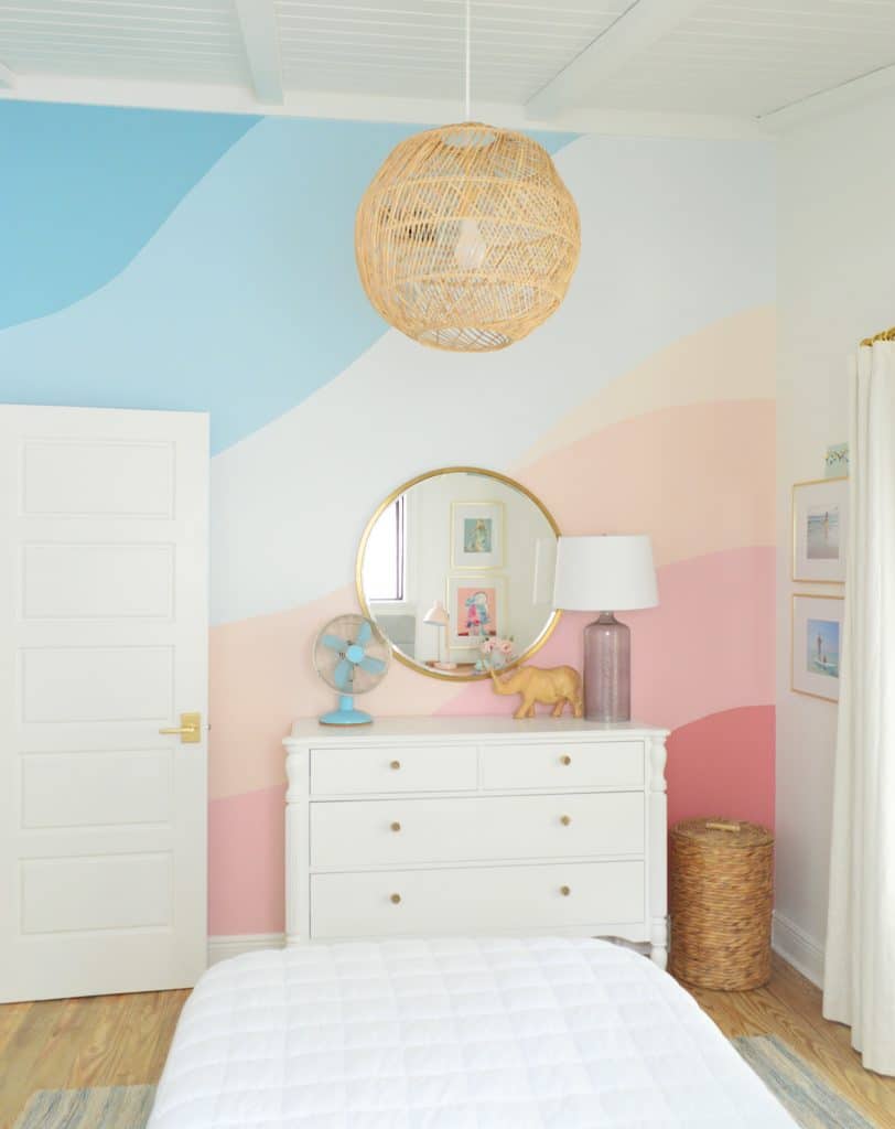Abstract painted mural in girls bedroom with pink and blue gradient stripes