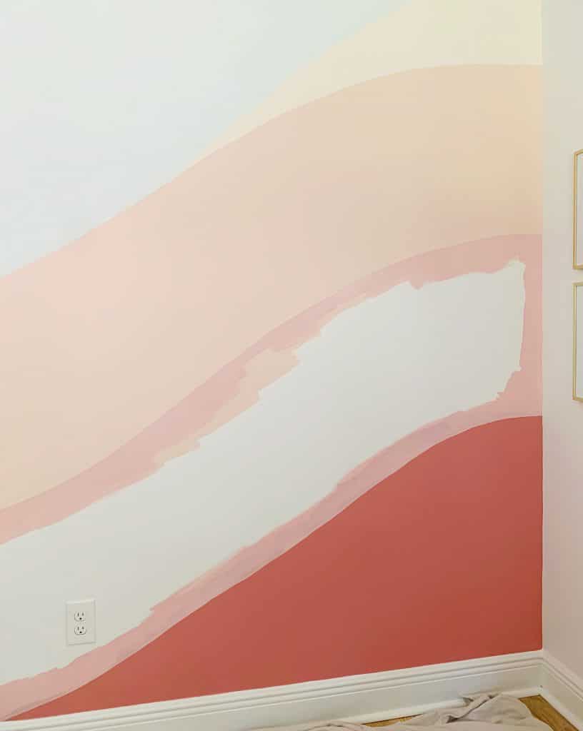 Crisp edges of pink paint between two colors on abstract wall mural