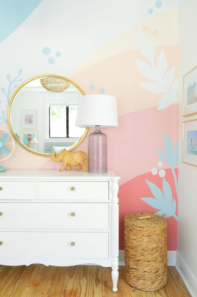 Quarto de menina com grande mural abstrato com listras coral azul-rosa