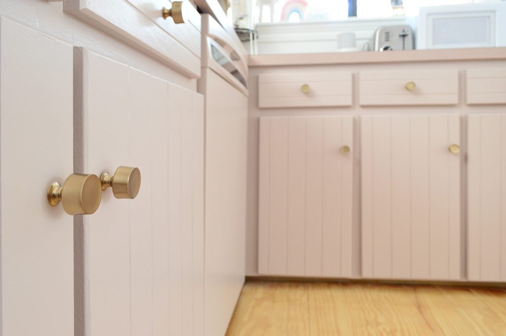 Close up after photo of mauve cabinets with brass gold hardware knobs