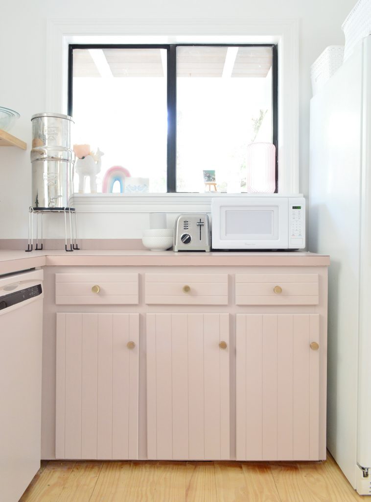 Kitchen with mauve cabinets and window above counter