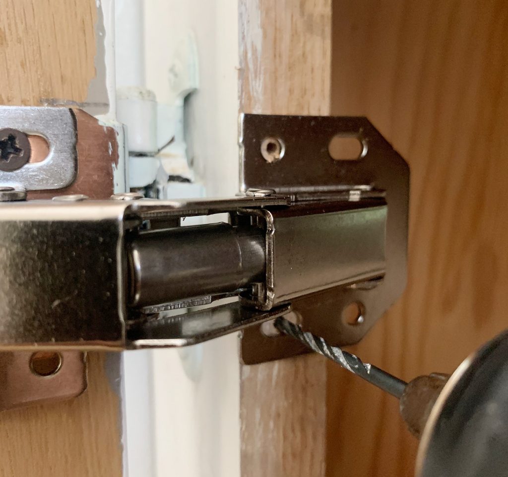 Drilling pilot hole through hidden cabinet hinge into cabinet frame