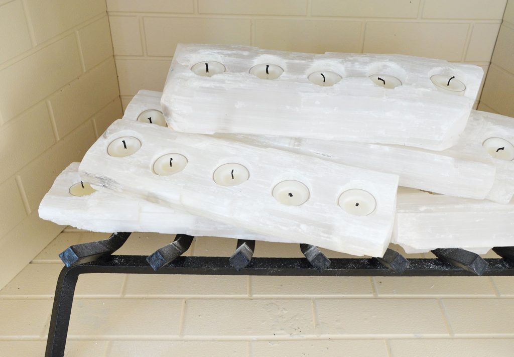 Close-up on crystal logs in fireplace with candles unlit