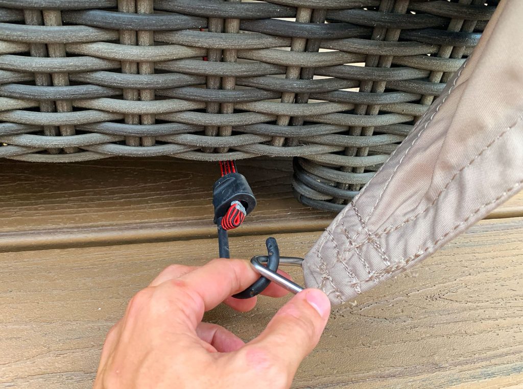 Close Up of Bungee Hook Looping Over Ring On Sun Sail Cover (Close Up do gancho do elástico sobre o anel na cobertura da vela solar)