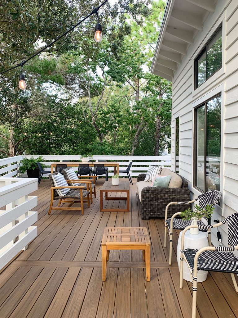 Second Floor Deck With Various Seating Areas Surrounded By Trees