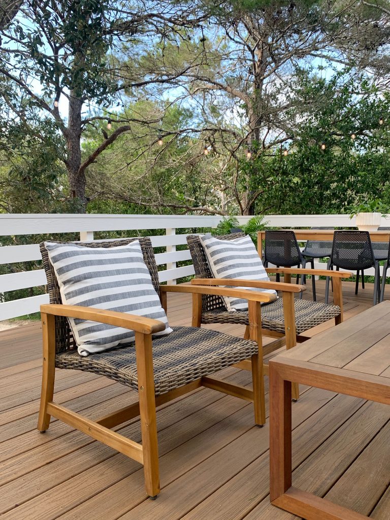 Two Woven And Wood Outdoor Lounge Chairs With Large Striped Pillows