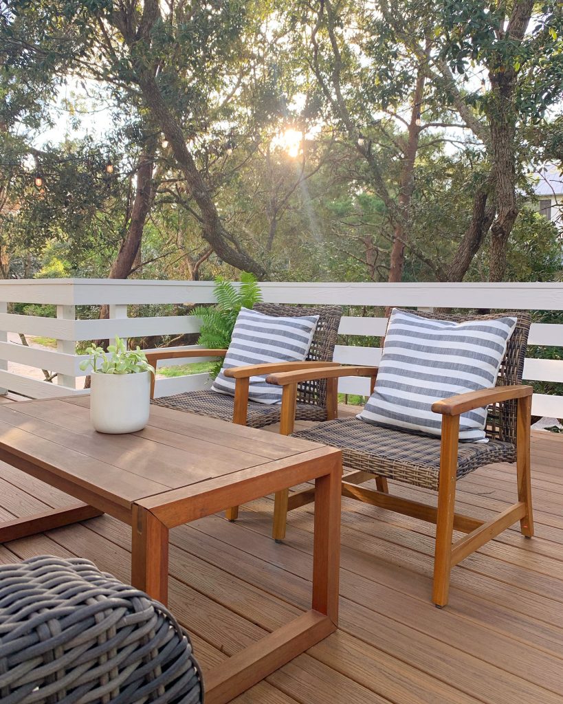 Sun Peeking Through Trees Above Deck Lounge Chairs