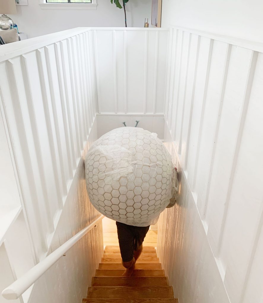 Oversized Capiz Globe Light Narrowly Fitting Up Stairs