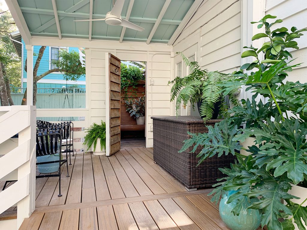 Covered Porch With Blue Ceiling And Open Door To Outdoor Shower