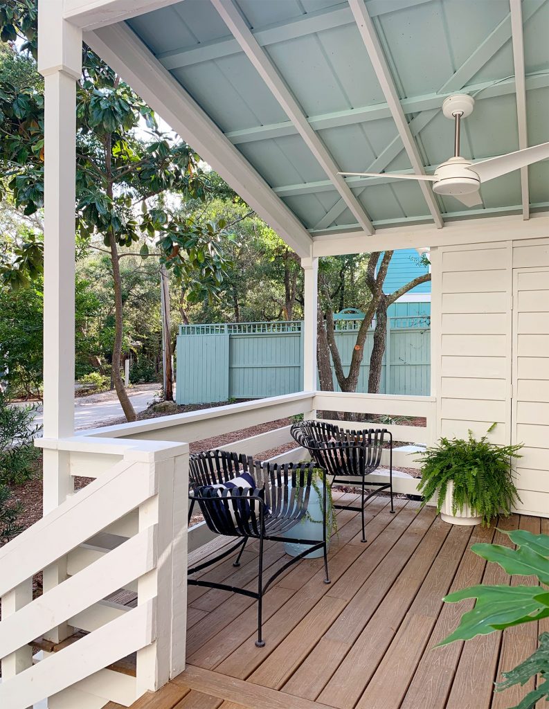 Blue Ceiling On Covered Porch With Ceiling Fan And Black Chairs