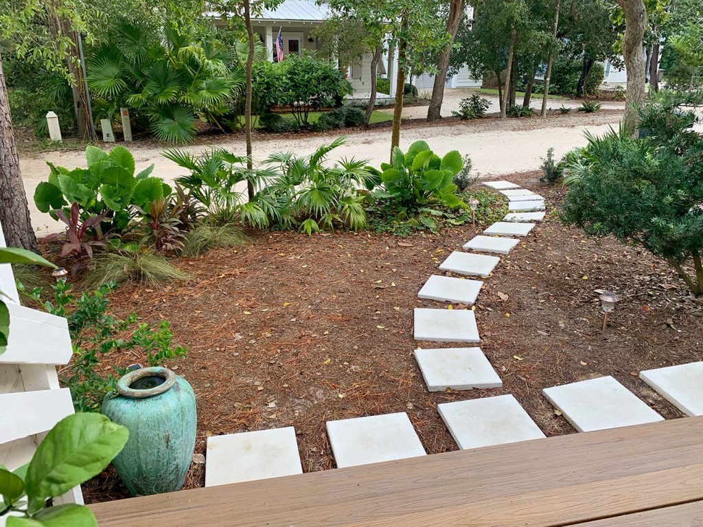 Pathway Of Square White Pavers Around Tropical Plantings