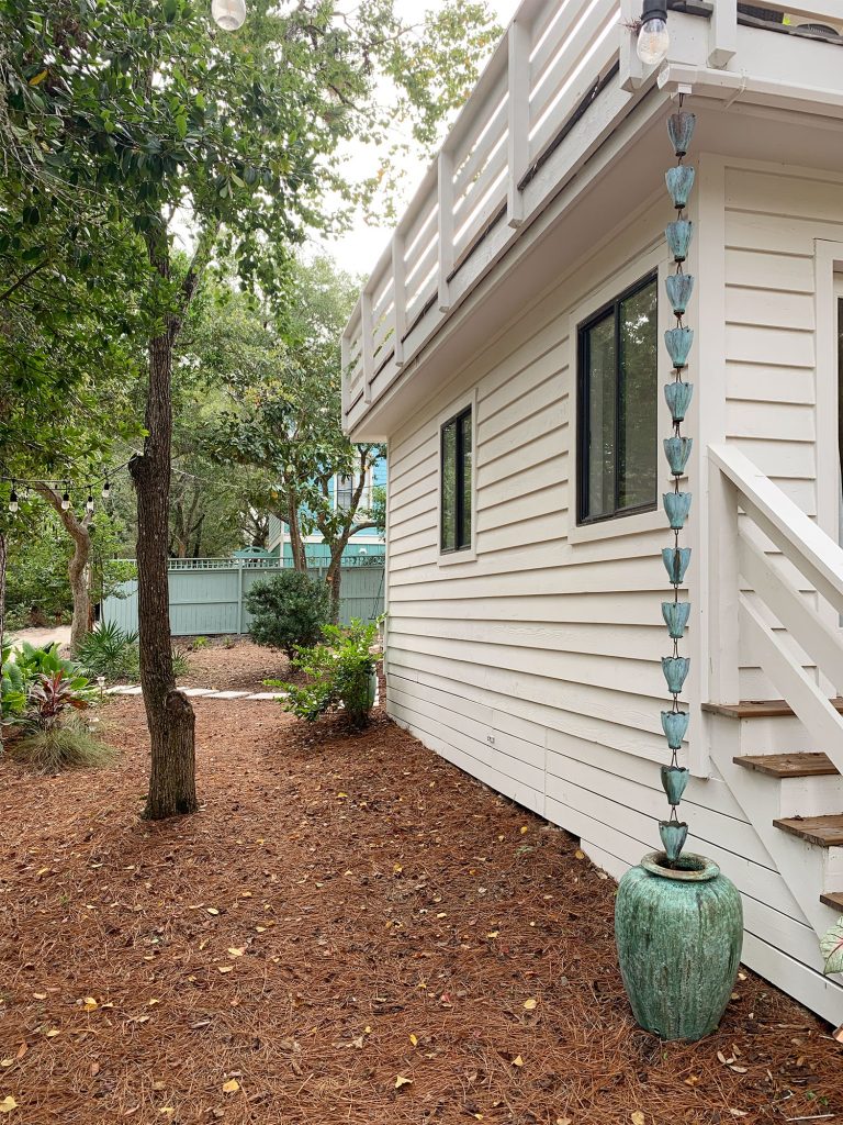 Copper Patina Rain Chain On Corner Of House Into Green Pot