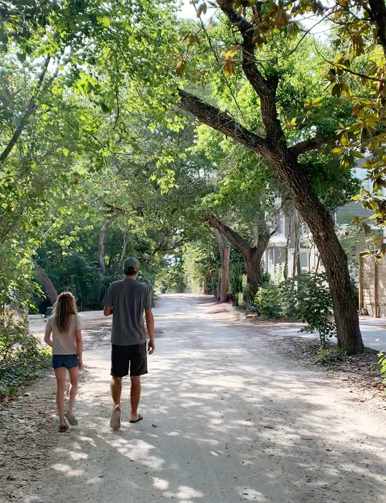 John and daughter walking in tree covered neighborhood