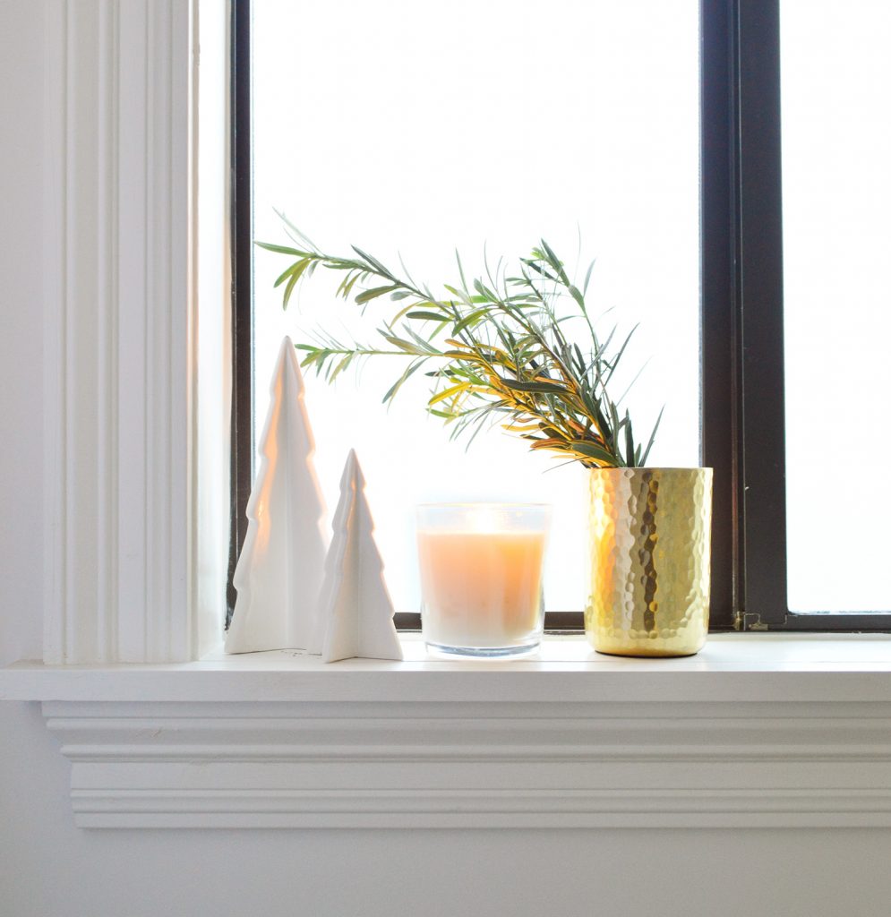 White Ceramic Trees With Candle And Gold Vase On Bathroom Window Sill