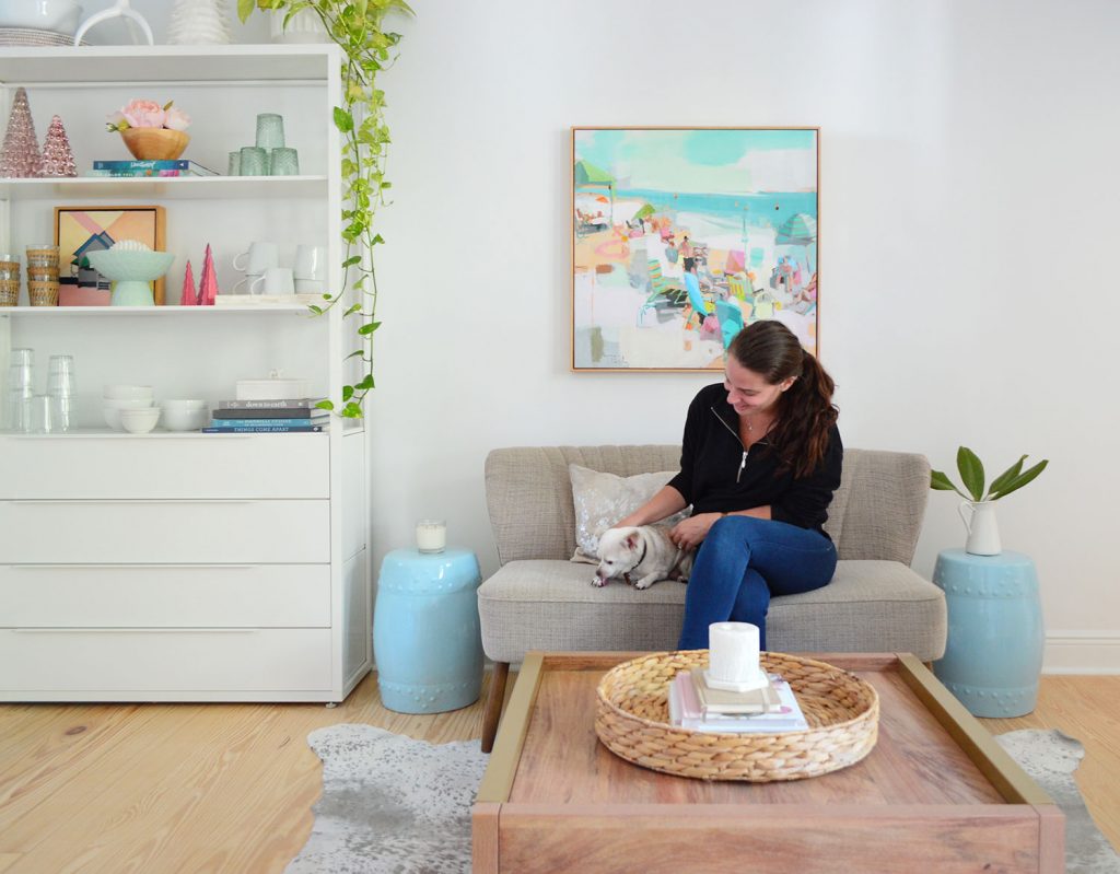 Sherry sitting on settee with chihuahua next to white metal shelf