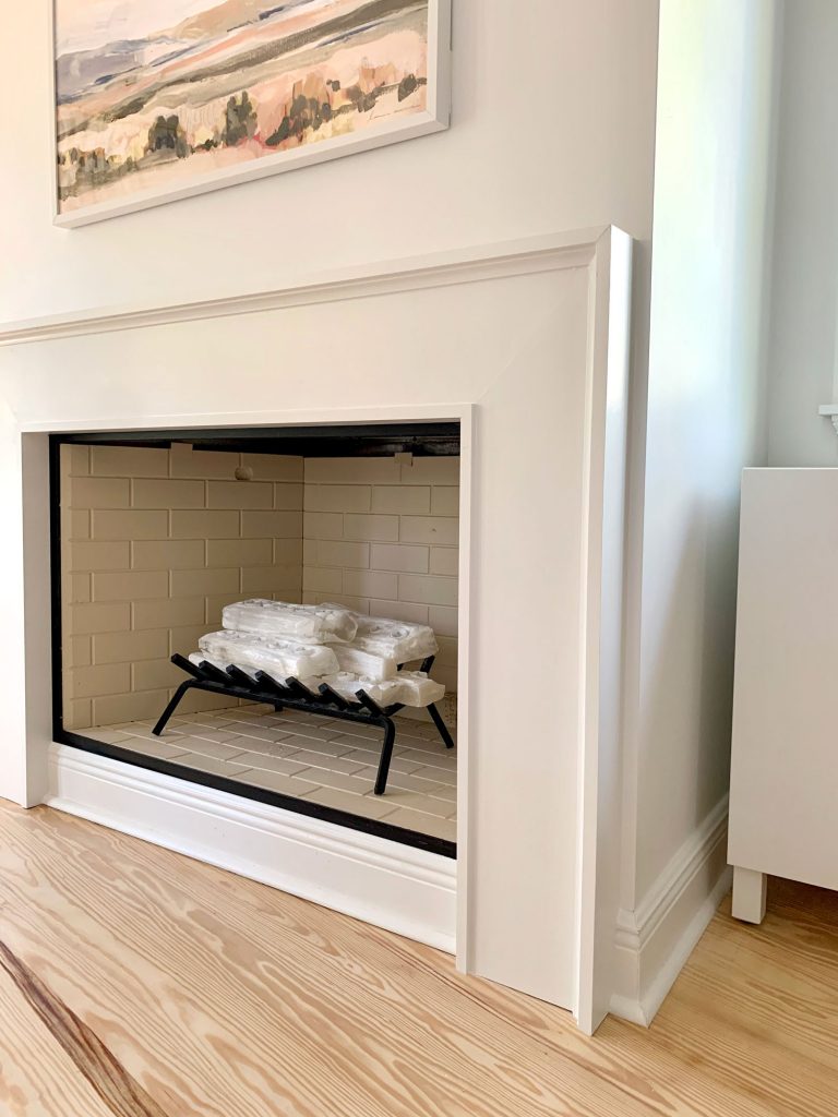 Closer view of fireplace surround  showing about an inch of drywall between it and corner of wall