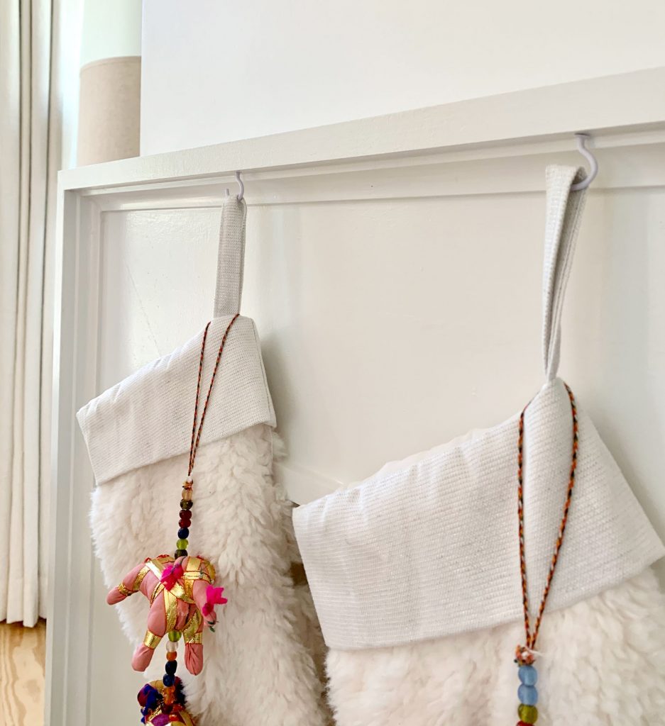Close up detail of stockings hanging from mantel using small white cup hooks
