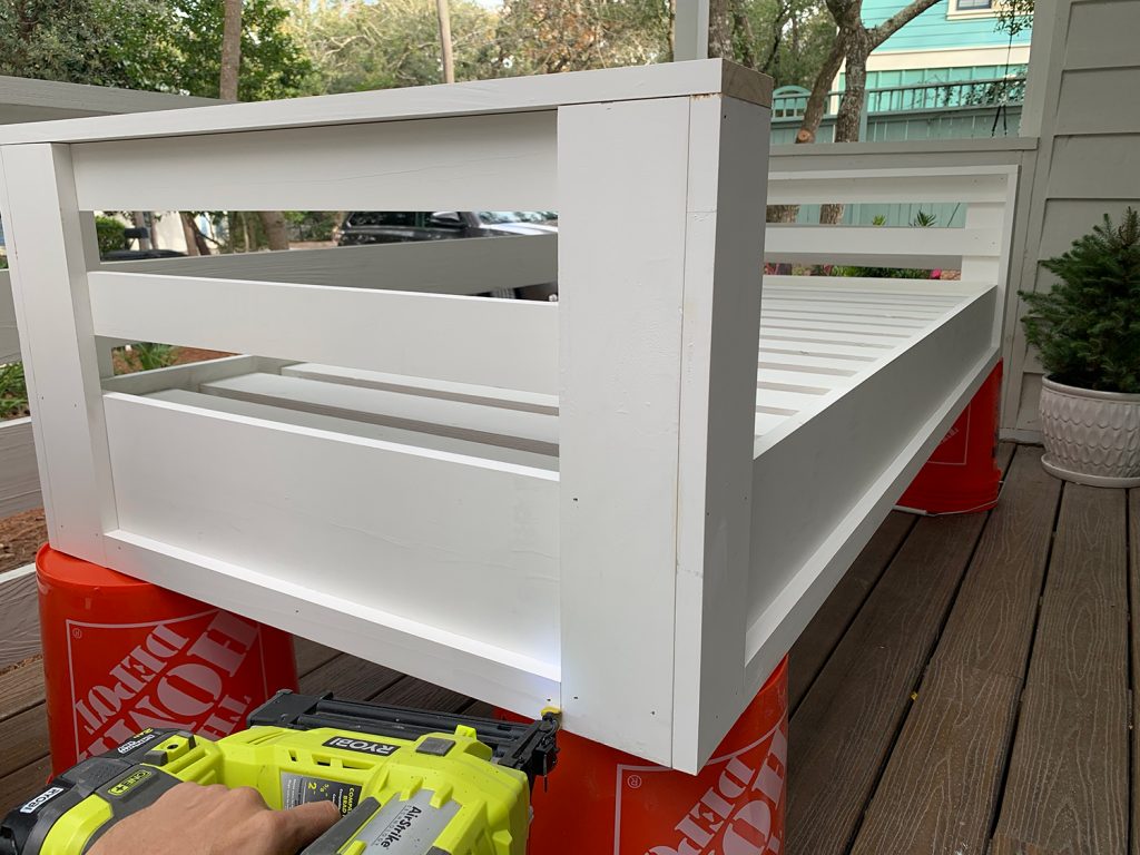 Nailing 1x2 trim piece along the bottom edge of hanging daybed