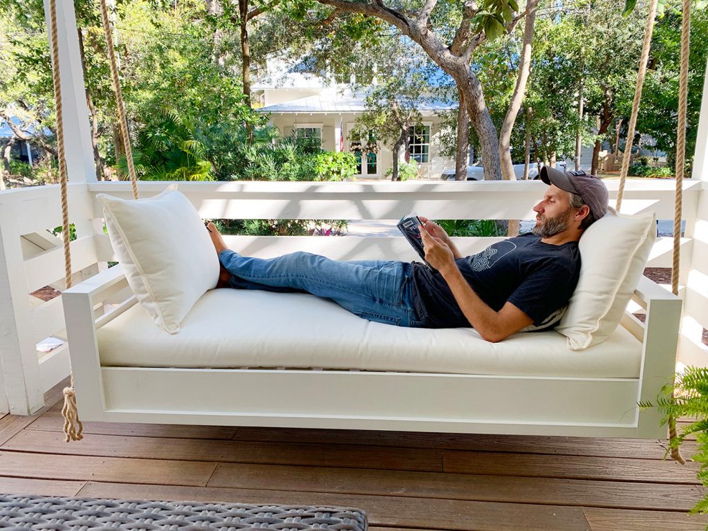 John Laying Fully Stretched Out On Hanging Daybed Swing