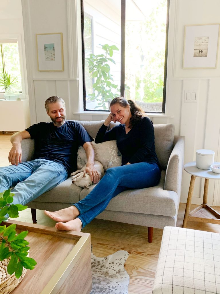 John and Sherry sitting with chihuahua on gray loveseat together