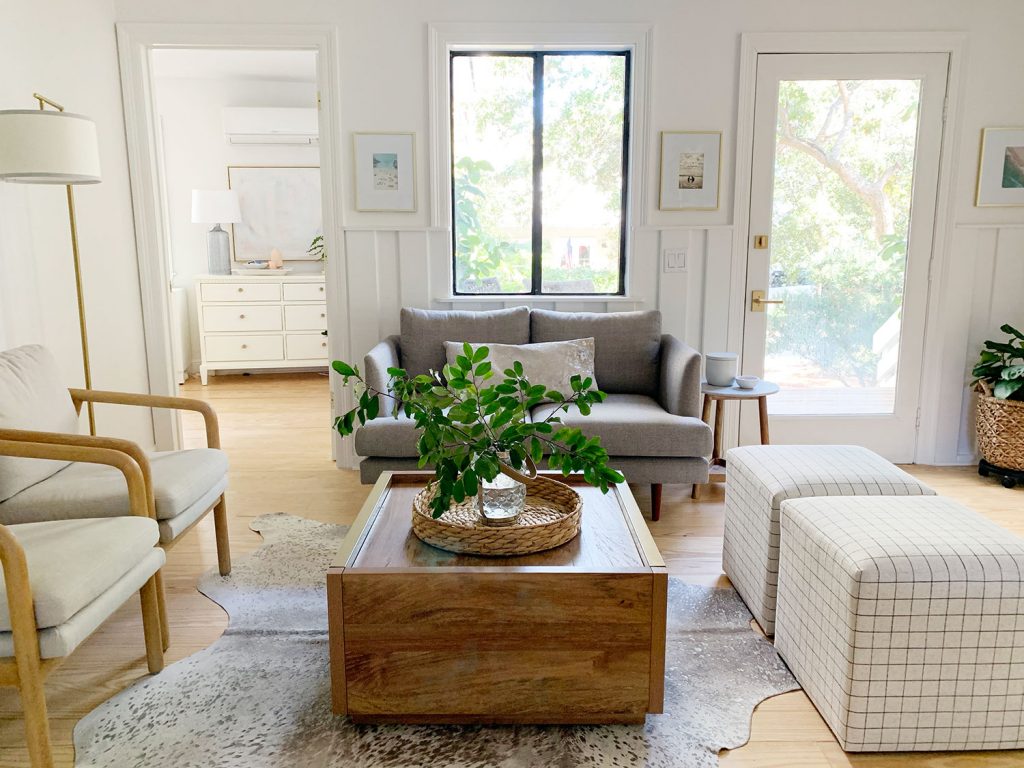 Sitting area including wood coffee table two plaid ottomans two arm chairs and gray loveseat