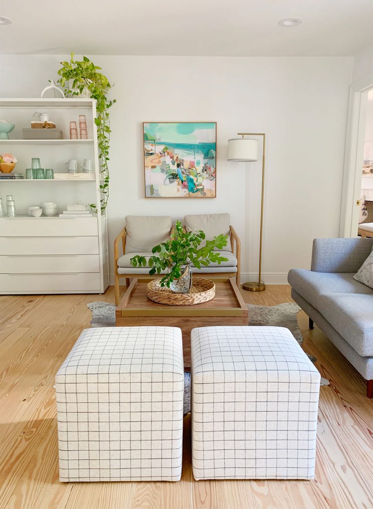 Straight view of sitting area with two plaid ottomans in foreground