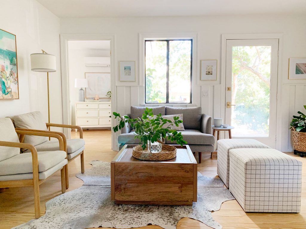 Sitting area including wood coffee table two plaid ottomans two arm chairs and gray loveseat