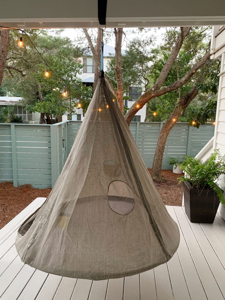 Hanging cone shaped netted tent above painted porch floor