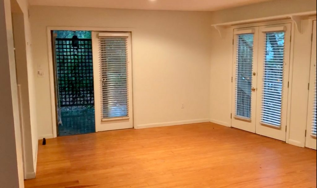 Before photo of bedroom as living room with door out to side porch