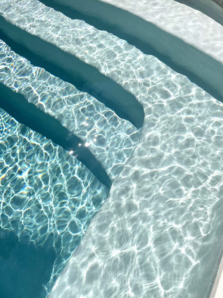 Detail photo of pool color getting darker as water gets deeper at steps Ivory DiamondBrite