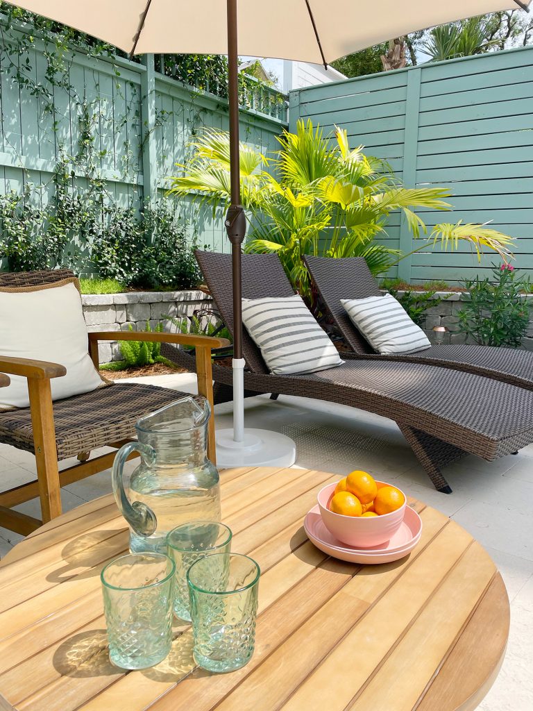 Pool patio area with brown chairs and wicker lounge chairs under umbrella