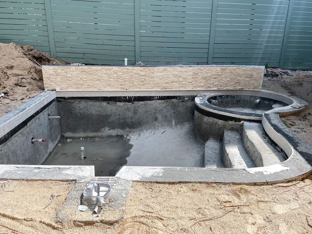 Concrete pool with tile applied around waterline and across accent retaining wall