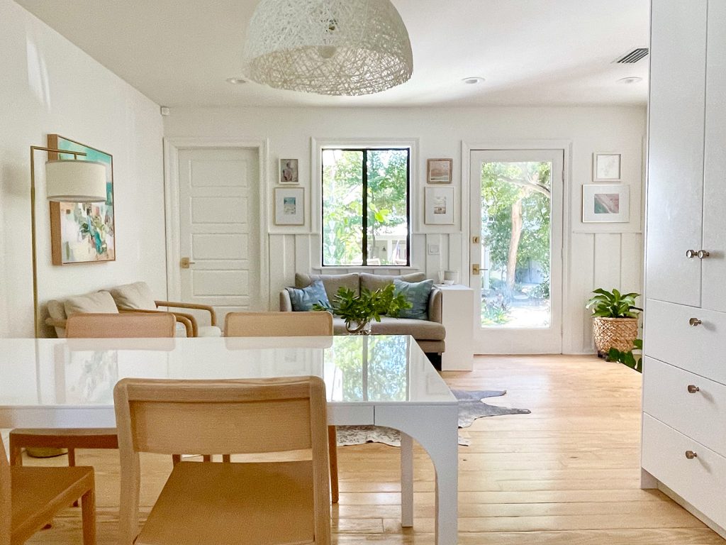 View Towards Sitting Area With White Modern Dining Table And Wood Chairs