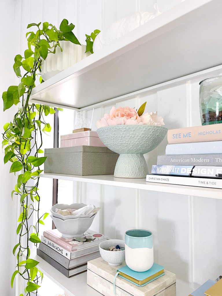 Side View Of Styled Shelves Of Ikea Fjalkinge Bookcase With Stacked Books And Plants