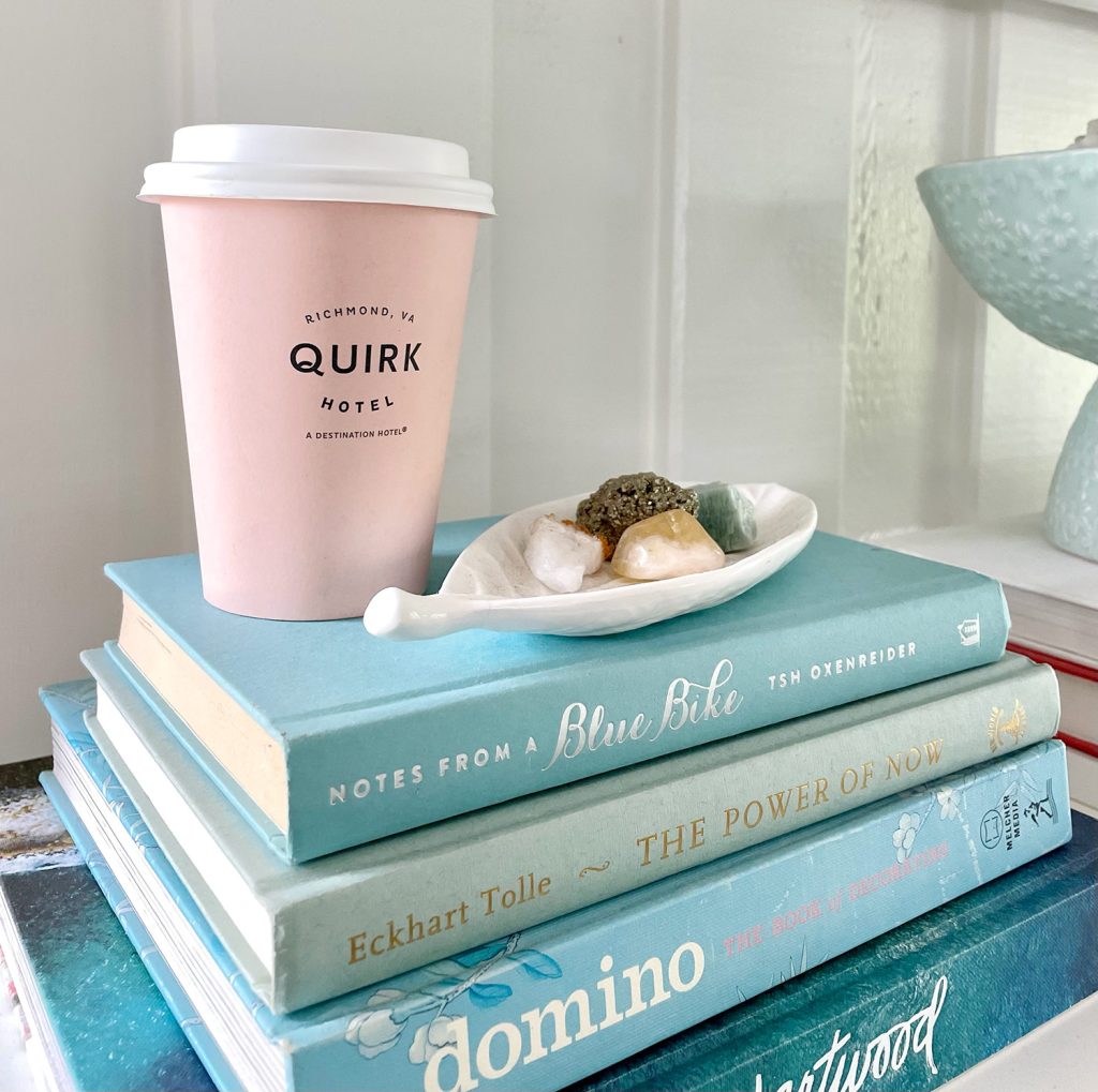 Close Up Of Stack of Blue Books With Pink Quirk Hotel Coffee Cup