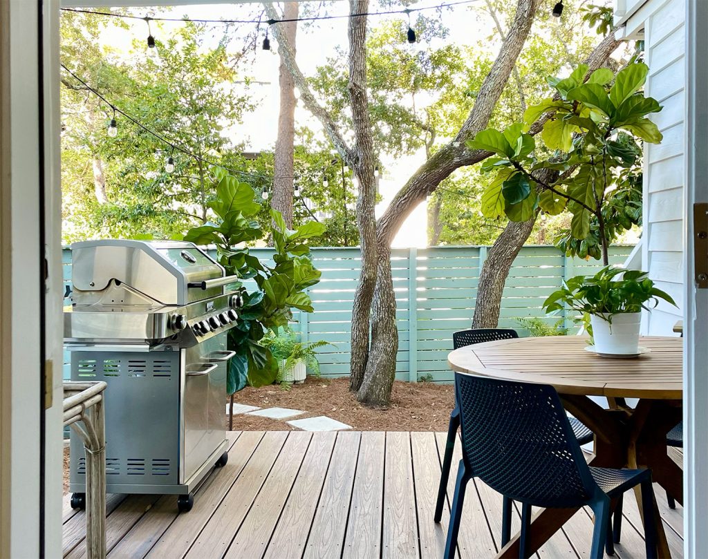 View of kitchen porch through door with trees and fence