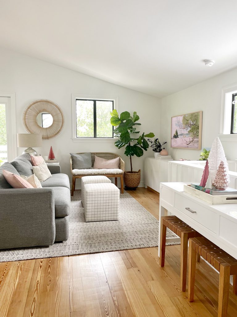 Angled view of living room with new sheepskin loveseat and decorative Christmas trees on tabletop