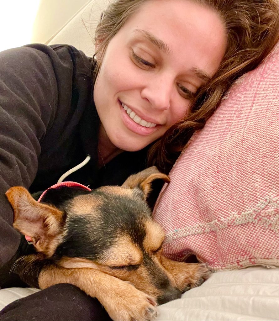 Penny the dog sleeping next to Sherry on pillow