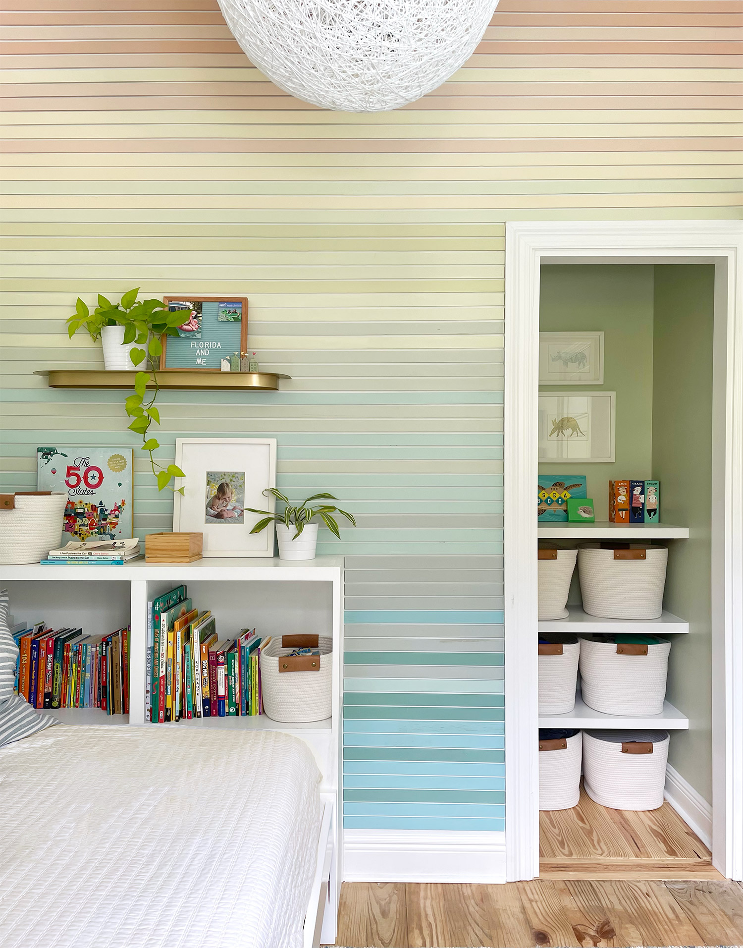 Boys bedroom with colorful planked wall treatment and built-in DIY bedside bookshelf