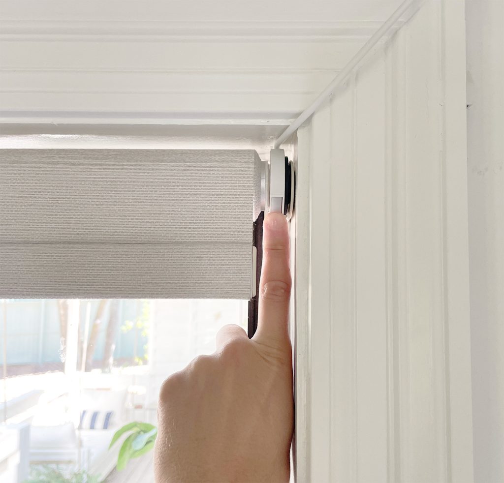 Finger Pressing Manual Button On Smart Roller Shade Blind In Case Of Emergency