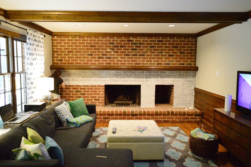 whitewash brick technique being applied to living room fireplace wall made of brick
