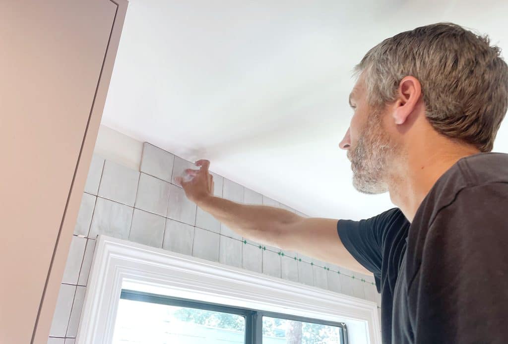 John adding last row of tiles above kitchen window