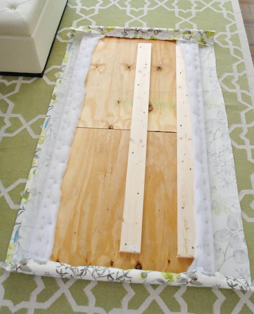 Both ends of fabric headboard stapled around back of wood frame