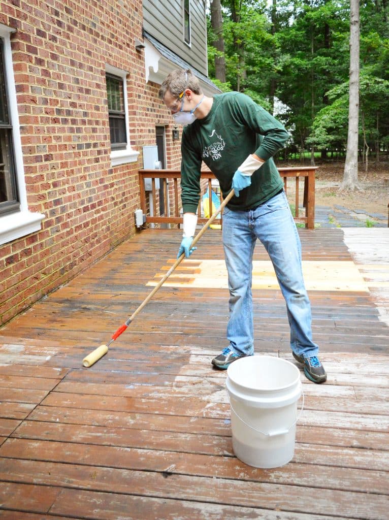 John rolling stripper on deck using a paint roller pole